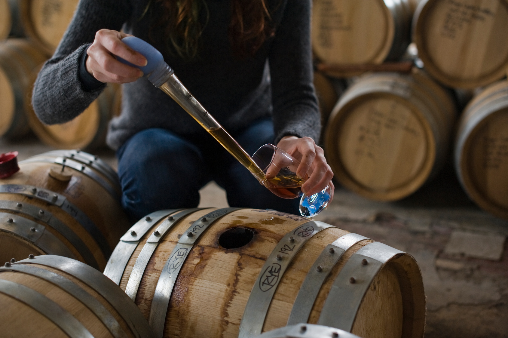 Female whiskey maker barrel tasting